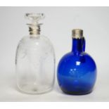 A silver mounted wheel engraved glass decanter and stopper and a white metal mounted Bristol blue