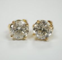 A pair of 750 yellow metal and solitaire diamond set ear studs, with a total carat weight of