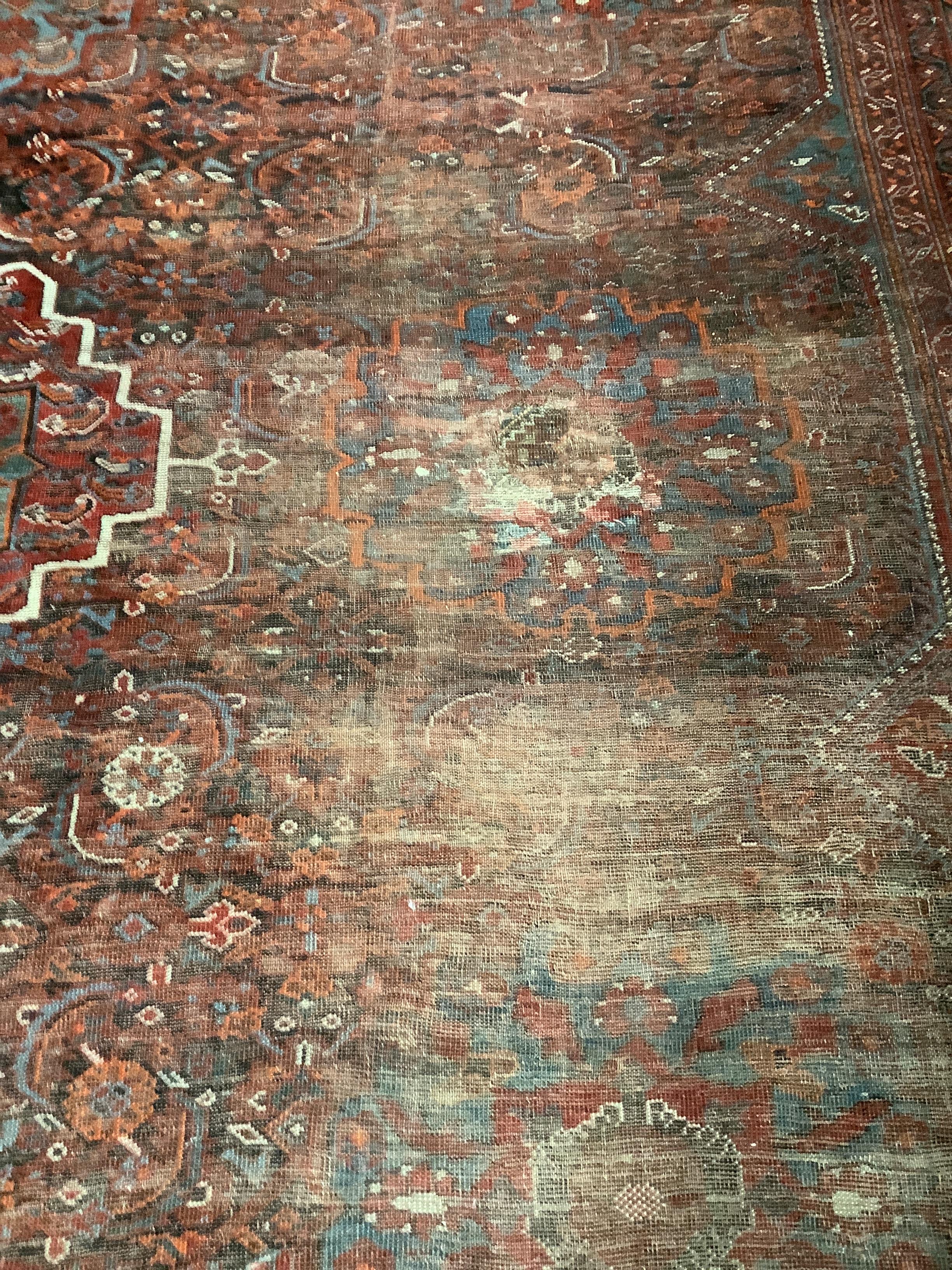 An early 20th century North West Persian red ground carpet, 410 x 348cm, worn and patch repaired. - Image 2 of 4