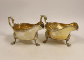 A pair of late Victorian silver sauceboats with gadrooned edge, double scroll handles on three shell