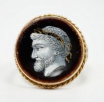 An antique 9ct and enamel set circular ring, depicting the head of a gentleman to dexter, size G,