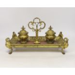 An ormolu inkstand with rouge marble base raised on four feet in the form of swans, 36cm wide