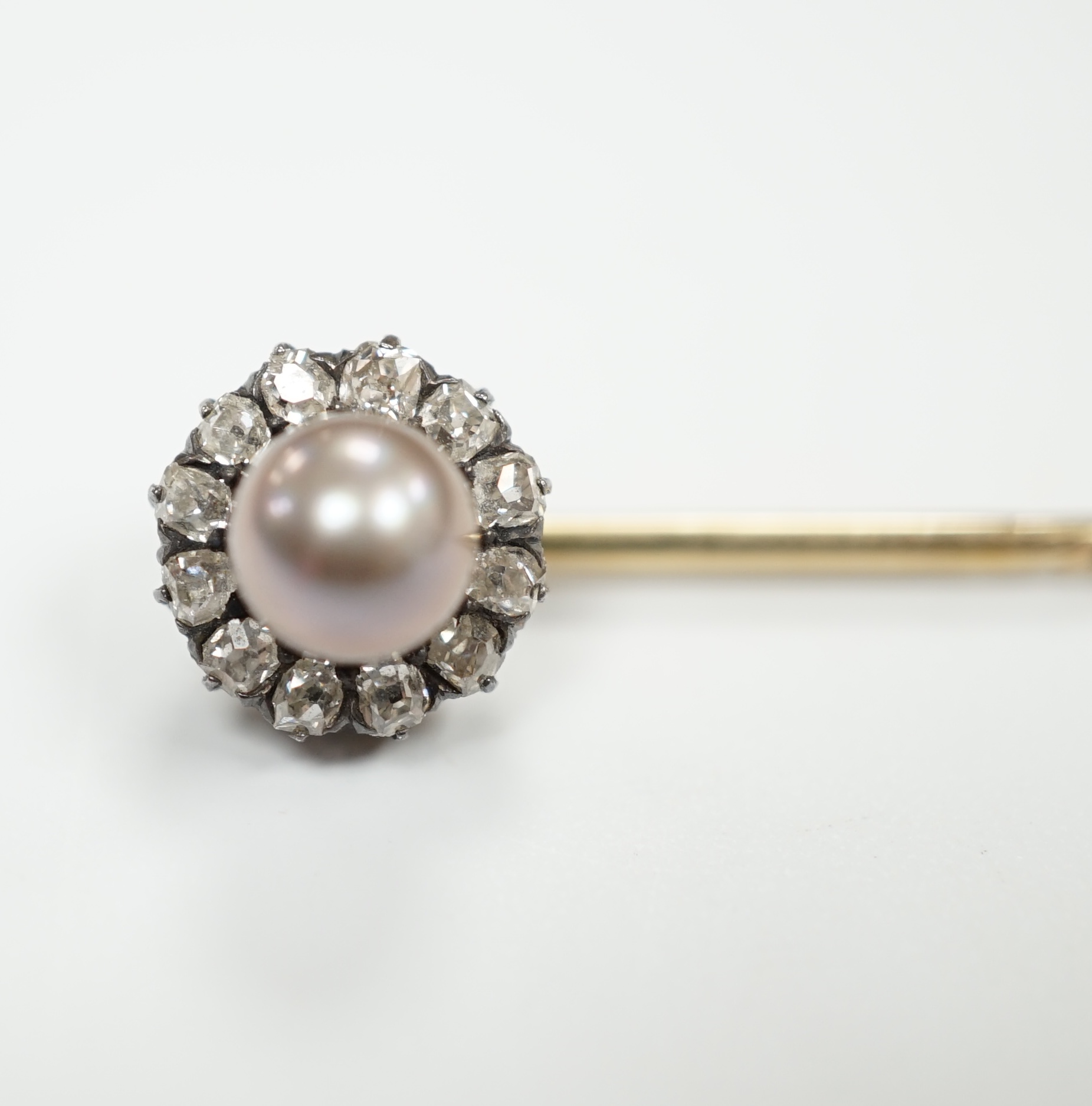 An early 20th century yellow metal, cultured pearl and old cut diamond cluster set stick pin,