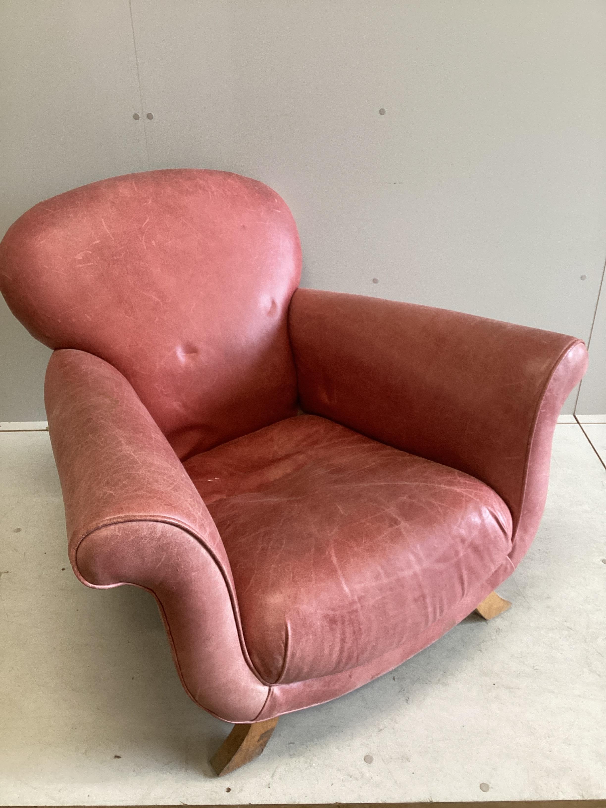 A Contemporary red leather scroll armchair, width 104cm, depth 94cm, height 80cm