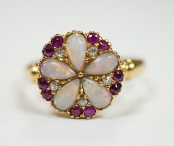An Edwardian 18ct gold, white opal, ruby and diamond cluster set ring, size K, gross weight 3.1