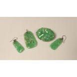 Four items of white metal mounted carved jade jewellery, comprising a brooch, 37mm, a pendant and