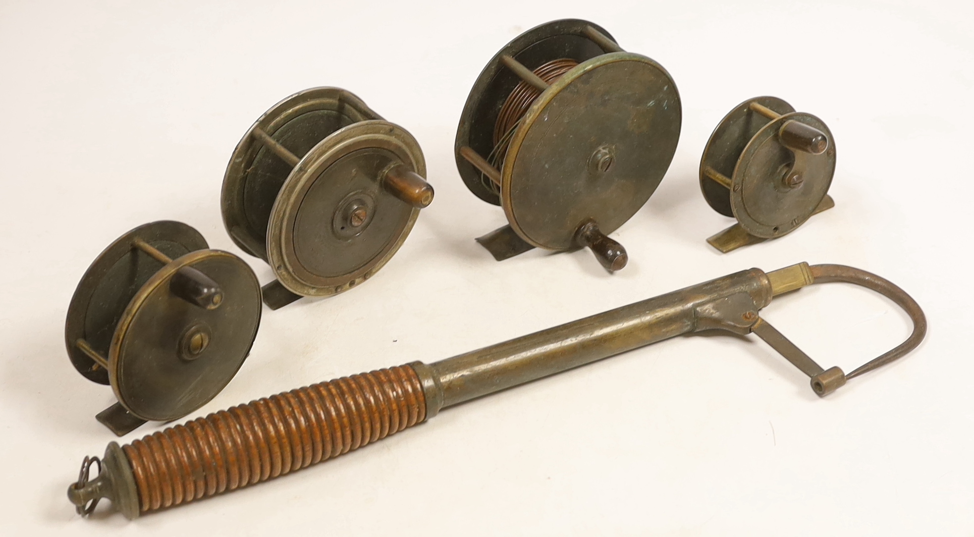 Four various sized fishing reels and a hook