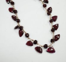 A Victorian yellow metal (test as 9ct) and garnet drop fringe necklace, set with facetted circular