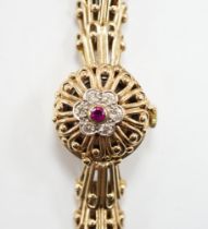 A lady's yellow metal manual wind bracelet watch, the dial with ruby and diamond cluster set