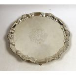 A George II silver salver, of shaped circular form, with shell and scroll border and engraved