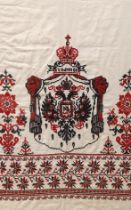 A framed Russian red and black cross stitch embroidered linen hanging of the Romanov coat of arms
