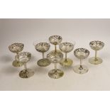 A matched set of eight pierced white metal coupes, two with glass inserts, six stamped with