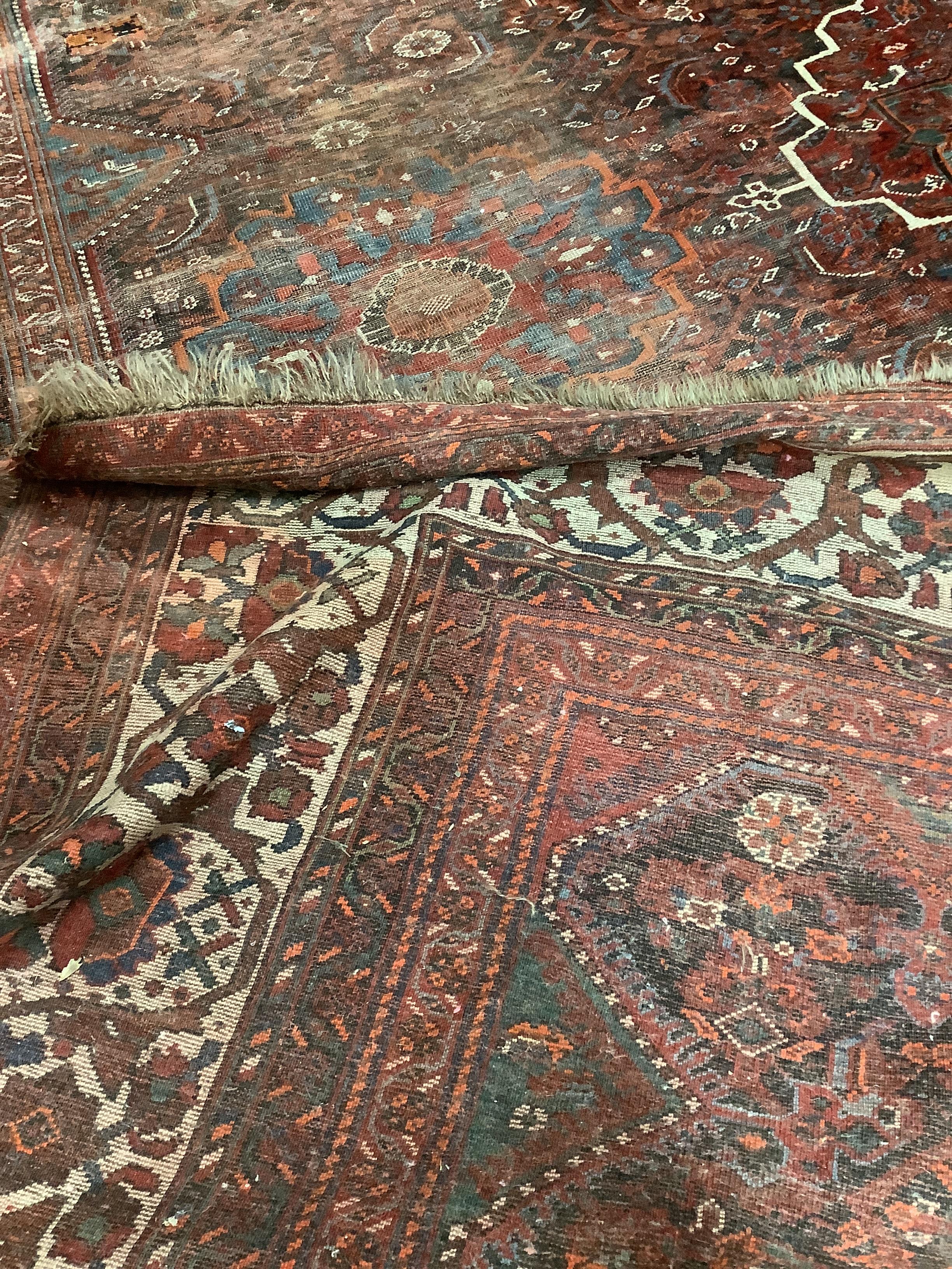 An early 20th century North West Persian red ground carpet, 410 x 348cm, worn and patch repaired. - Image 4 of 4