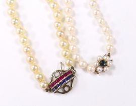 Two single strand cultured pearl necklaces, including one with channel set ruby and sapphire set