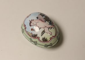 A silver plated and painted enamel egg shaped box and cover, opening to reveal a hinged pocket watch