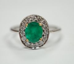 A white metal, emerald and diamond set oval cluster ring, size M, gross weight 2.8 grams.