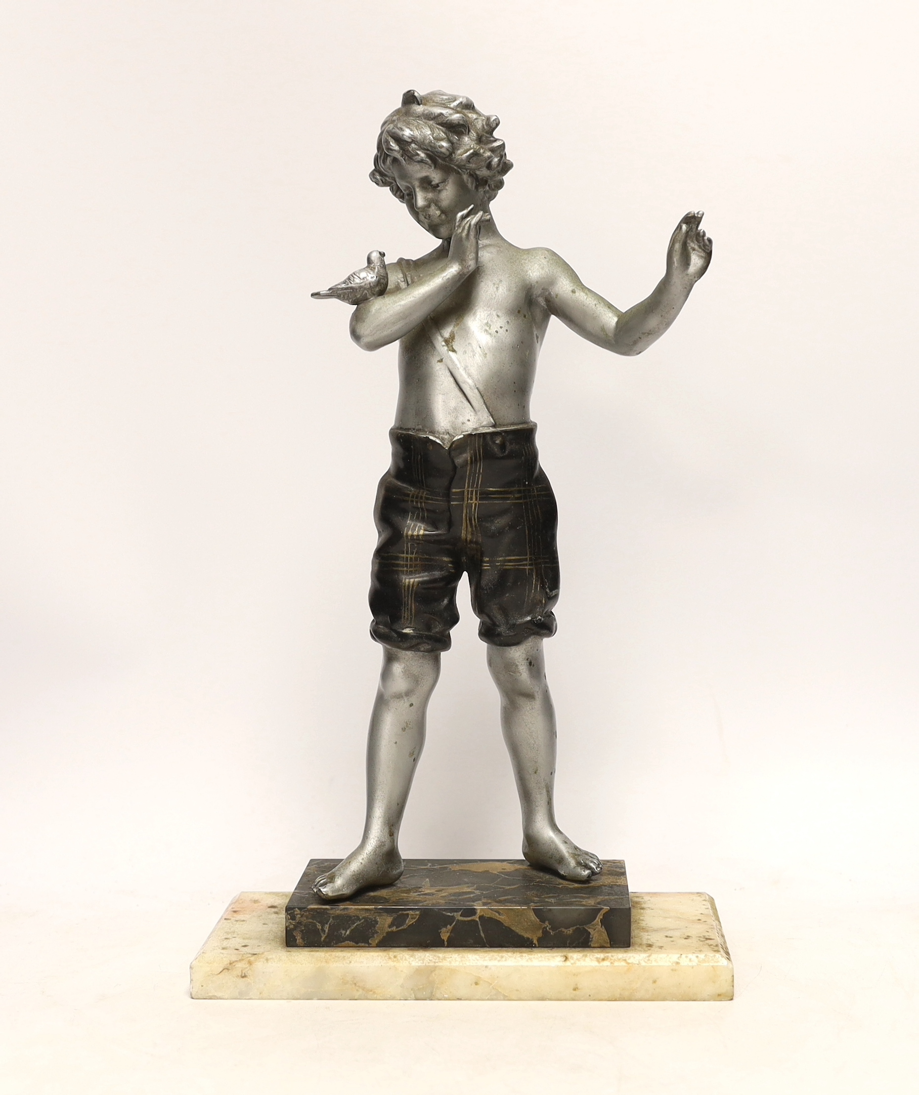A spelter figure of a boy with bird on two step marble base, 39.5cm high