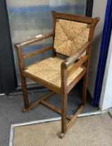 An early 20th century Arts and Crafts rush seat and back oak elbow chair, width 57cm, depth 48cm,