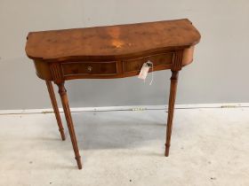A reproduction yew wood two drawer serpentine side table, width 80cm, depth 34cm, height 73cm
