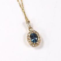 A yellow metal, blue topaz and diamond set oval cluster pendant, 11mm, on a 375 fine link chain,