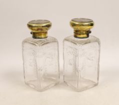 A pair of George V silver gilt mounted cut and etched glass square scent bottles and stoppers,