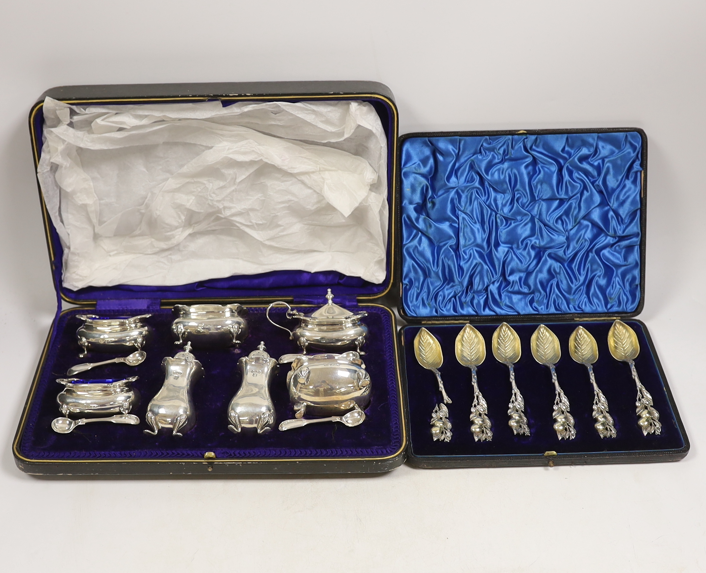 An Edwardian cased silver seven piece condiment set with four matching spoons, Hukin & Heath,
