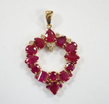 A modern 14k, ruby(treated) and diamond cluster set open work pendant, overall 52mm, gross weight