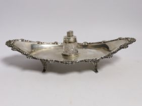 A late Victorian silver navette shaped inkstand, with silver mounted cut glass well, on four