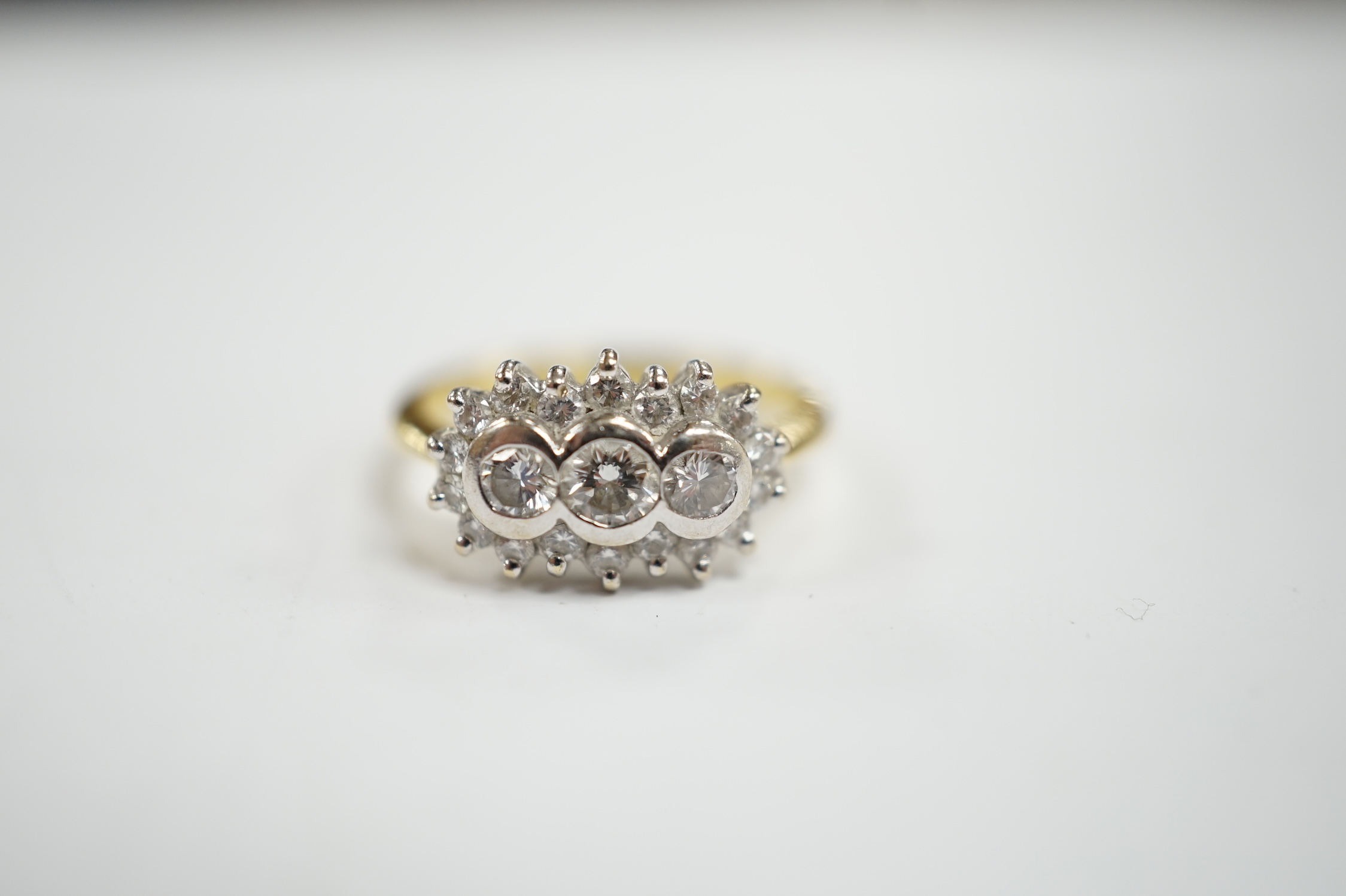 A modern 18ct gold and collet set three stone diamond ring, with diamond chip set border, size J/ - Image 2 of 4