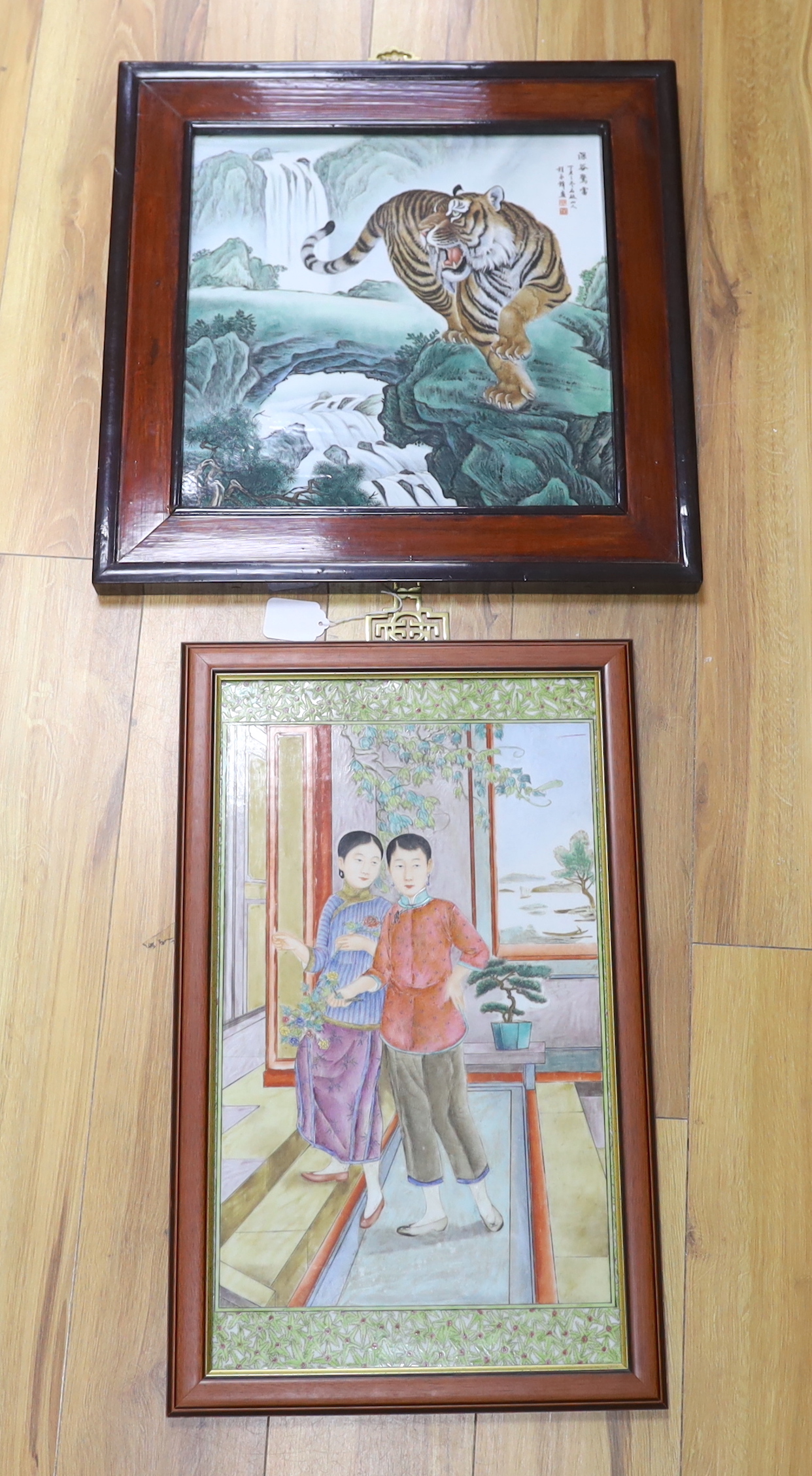 Two Chinese framed enamelled porcelain plaques, one of a tiger and another of two girls, largest