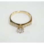 A modern 14k and single stone diamond set ring, with diamond chip set shoulders, size M, gross