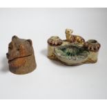 A Black Forest carved bear inkwell and a majolica inkwell surmounted with a dog, largest 14cm wide