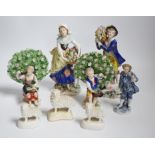 A pair of Derby style porcelain small bocage figures, a boy and girl seated with grape filled