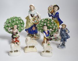 A pair of Derby style porcelain small bocage figures, a boy and girl seated with grape filled