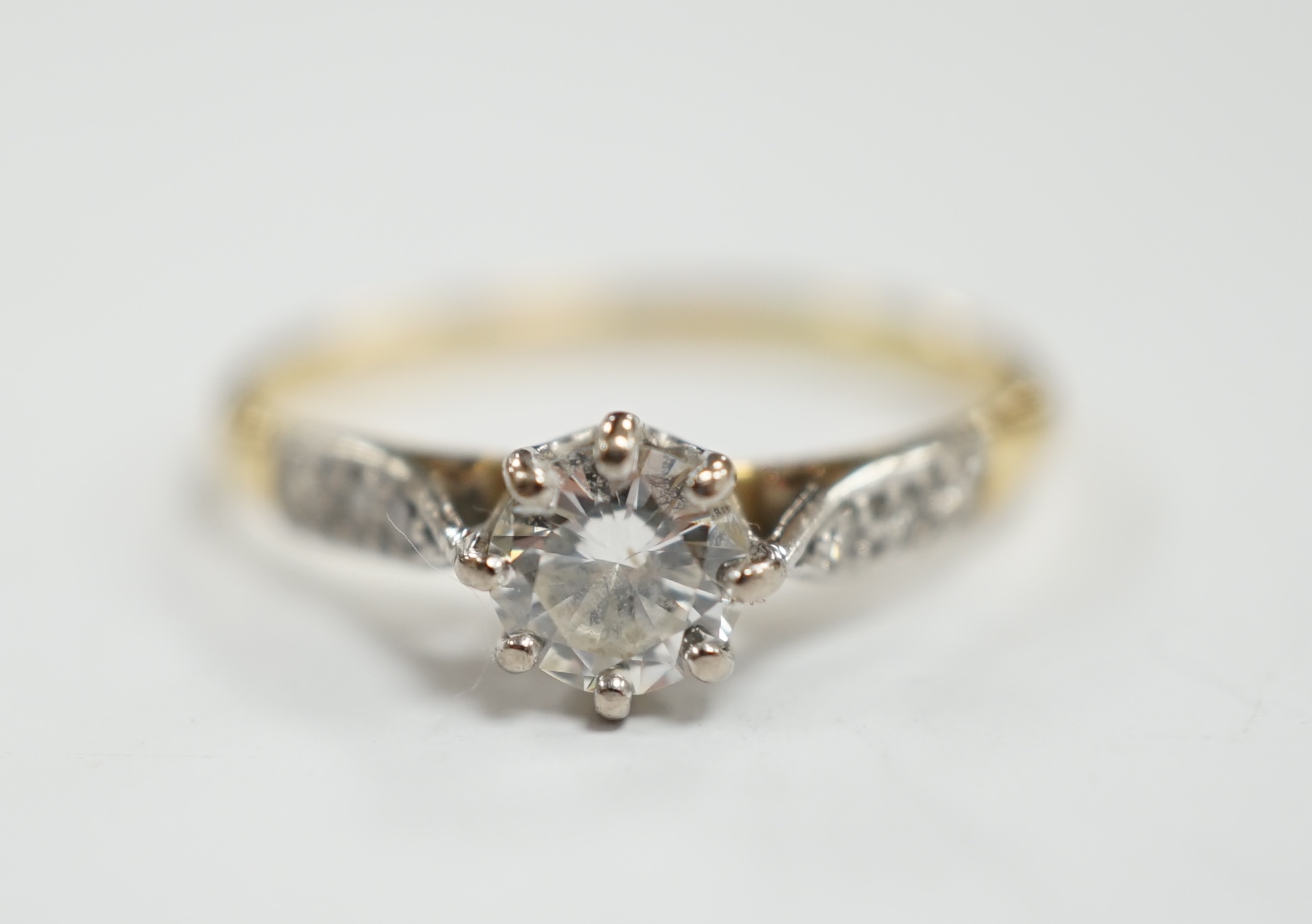 An 18ct and single stone diamond set ring, with diamond chip set shoulders, size M, gross weight 1.9