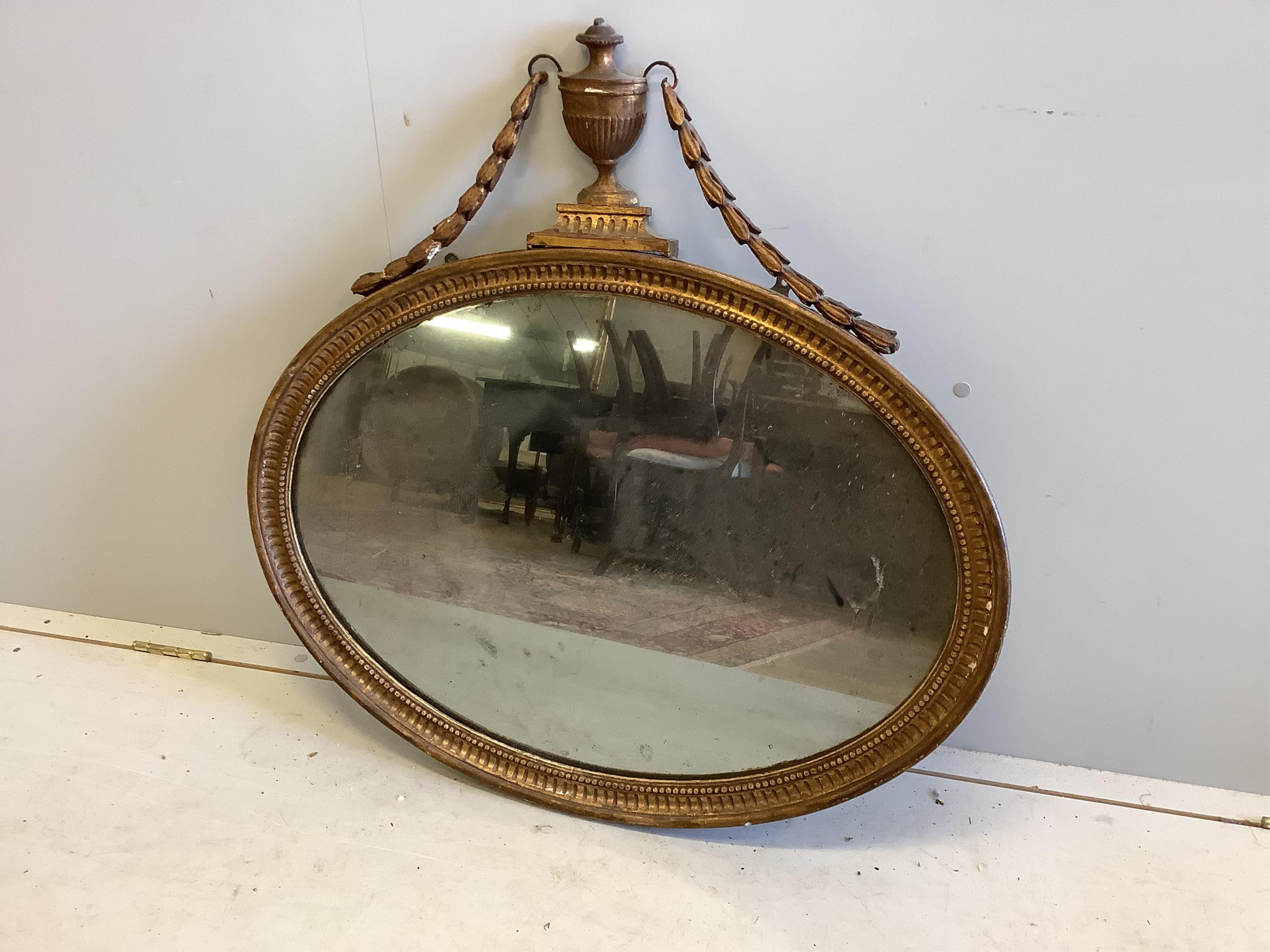 A Sheraton style oval giltwood and composition wall mirror, width 80cm, height 80cm