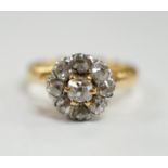 An early 20th century French 18k and nine stone diamond set flower head cluster ring, size G,