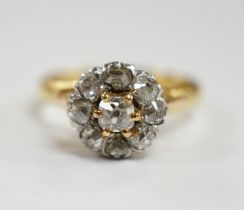 An early 20th century French 18k and nine stone diamond set flower head cluster ring, size G,