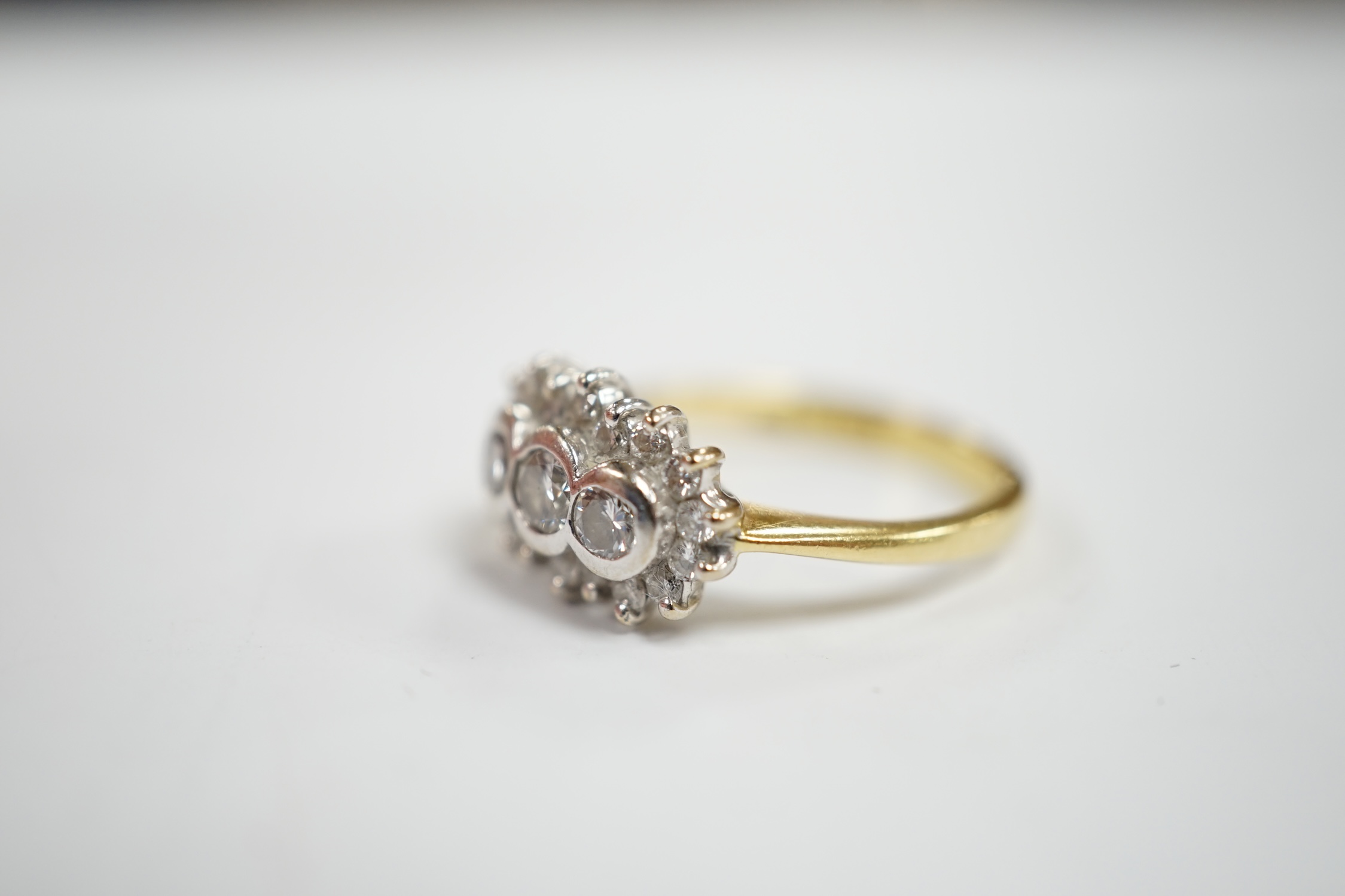 A modern 18ct gold and collet set three stone diamond ring, with diamond chip set border, size J/ - Image 3 of 4
