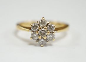 A modern 18ct gold and seven stone diamond cluster set flower head ring, size N, gross weight 3.6