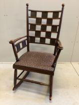 An Arts & Crafts rocking chair, the tablet back with Latin inscription, width 60cm, depth 52cm,
