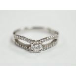 A modern 18ct white gold and single stone diamond set ring, with diamond chip set split shoulders,