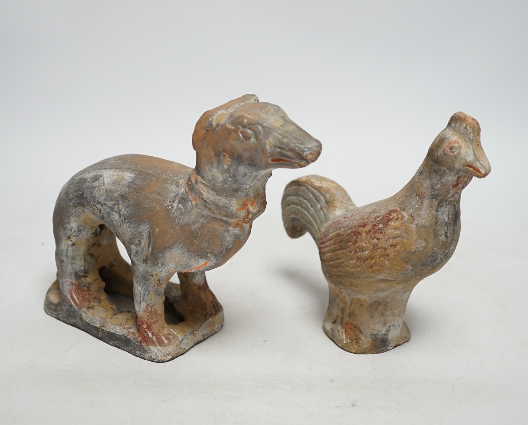 Two Chinese pigment painted figures of a cockerel and a dog, Han dynasty or later, 17cm