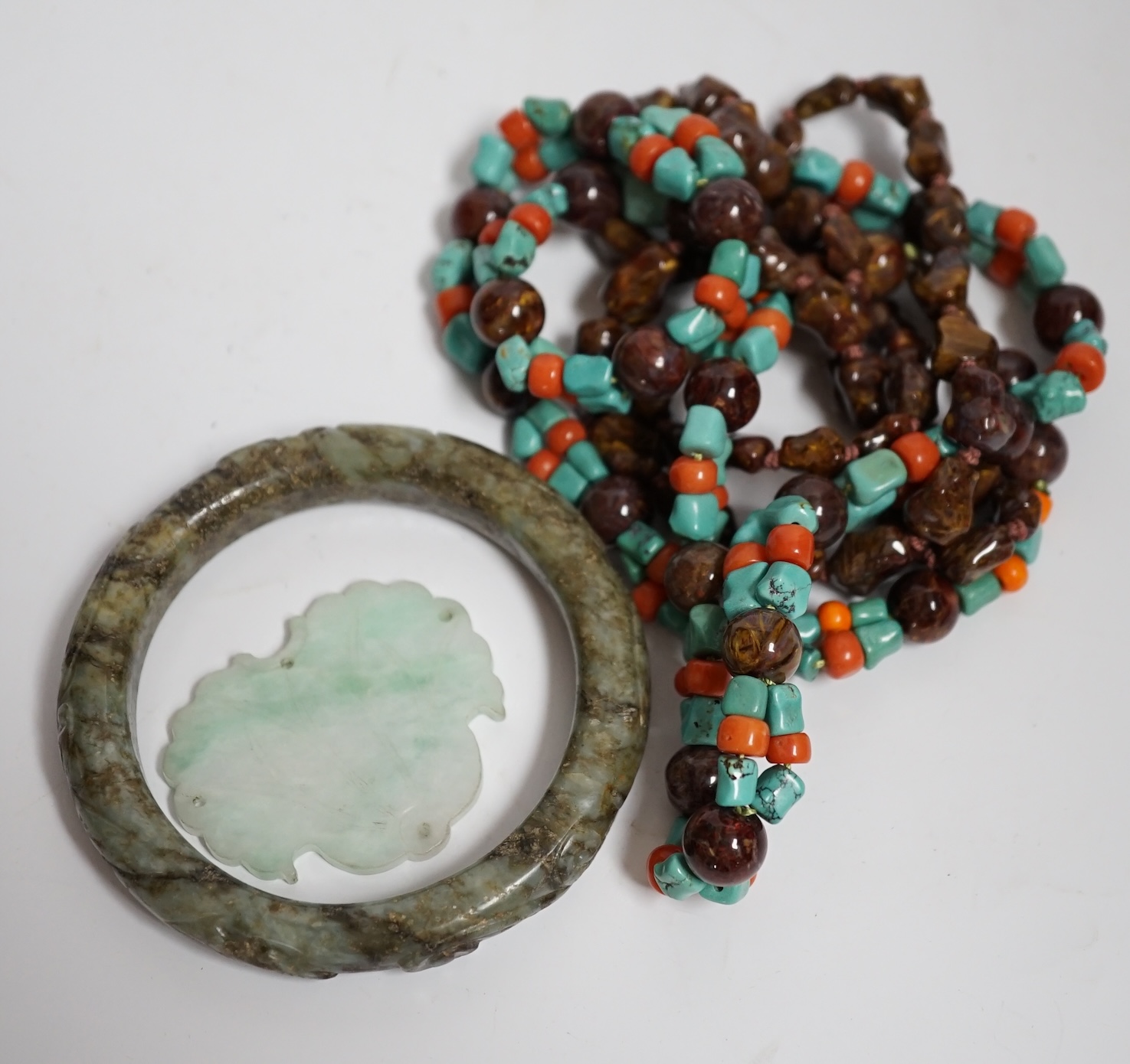 Two Chinese hardstone necklaces, a carved bangle and a jade carving, bangle 8.5cm in diameter
