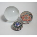 Two millefiori paperweights and a glass ball, largest 10cm in diameter