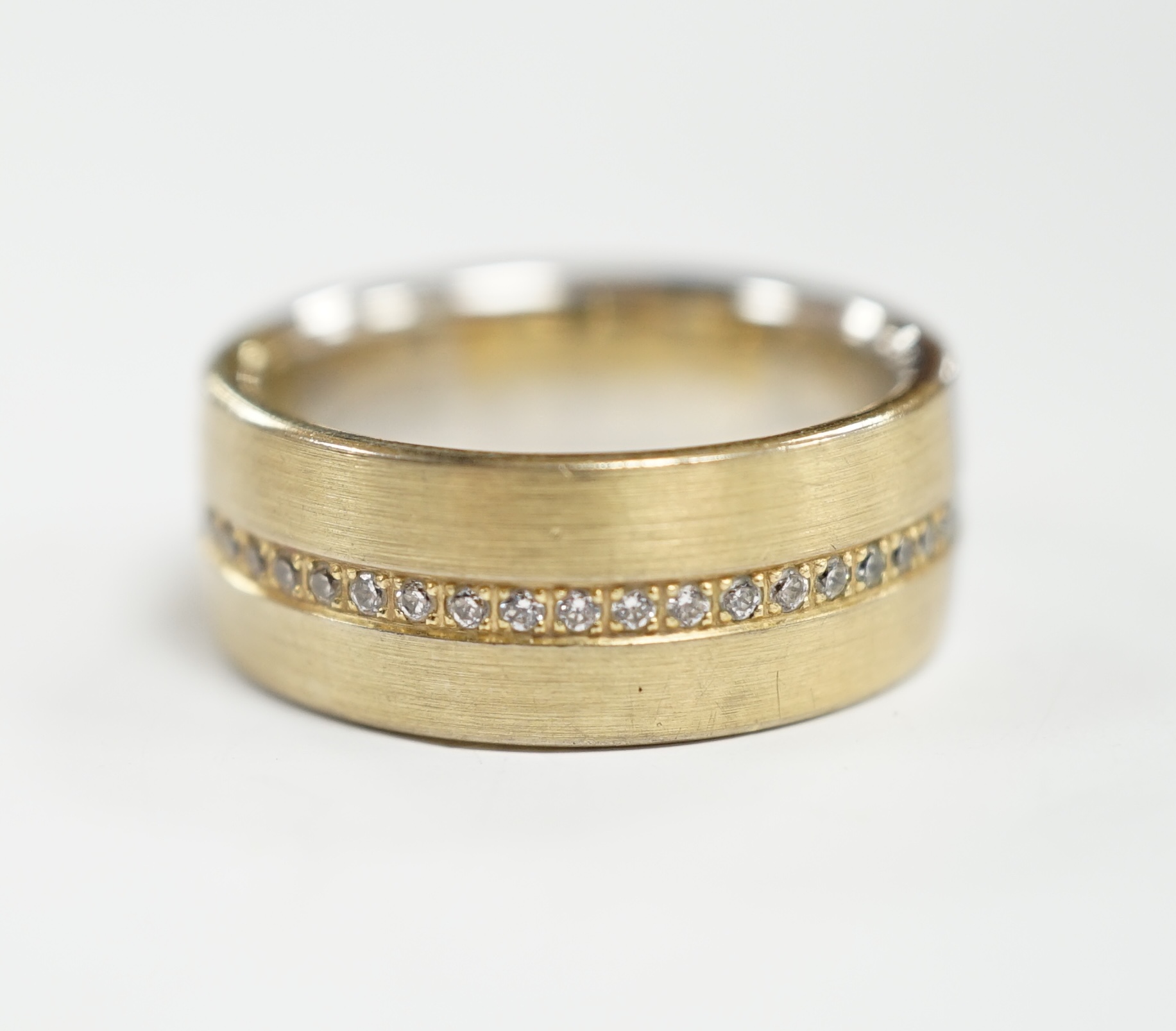 A two colour base metal band, with central row of simulated diamonds, size O.