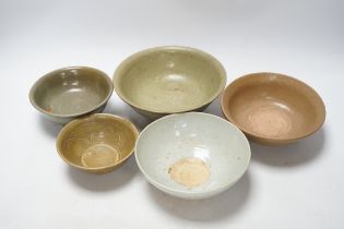 A group of four Chinese Longquan or Yue ware celadon bowls and a Qingbai bowl, Song-Yuan dynasty,