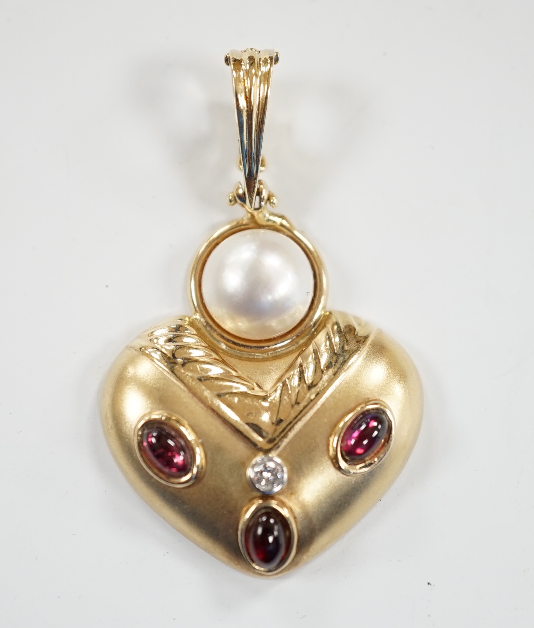 A modern unmarked yellow metal, mabe pearl, cabochon garnet and diamond set pendant, width 28mm,