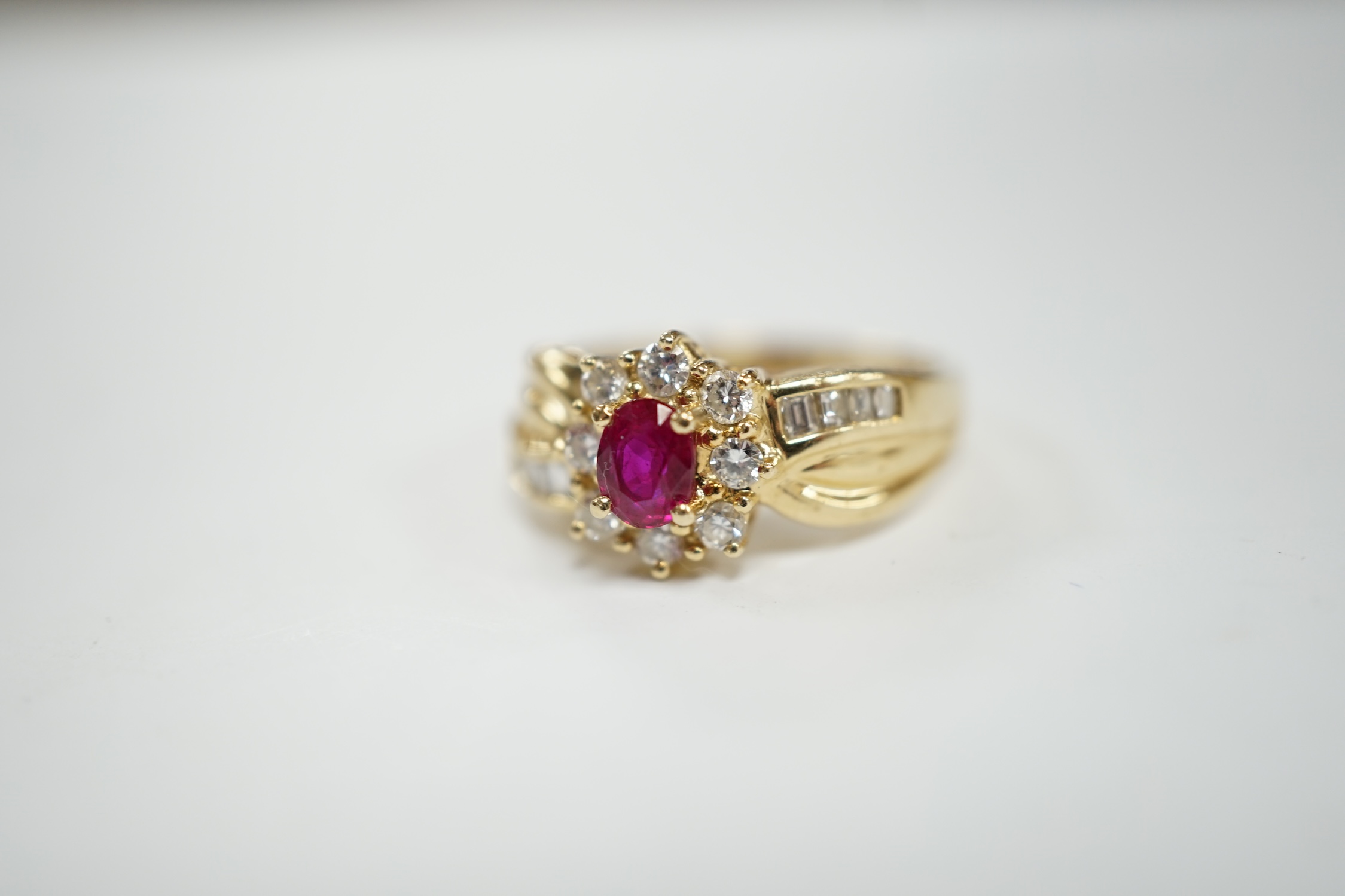 A modern 14k, ruby and diamond set oval cluster dress ring, with diamond chip set shoulders, size P, - Image 2 of 4