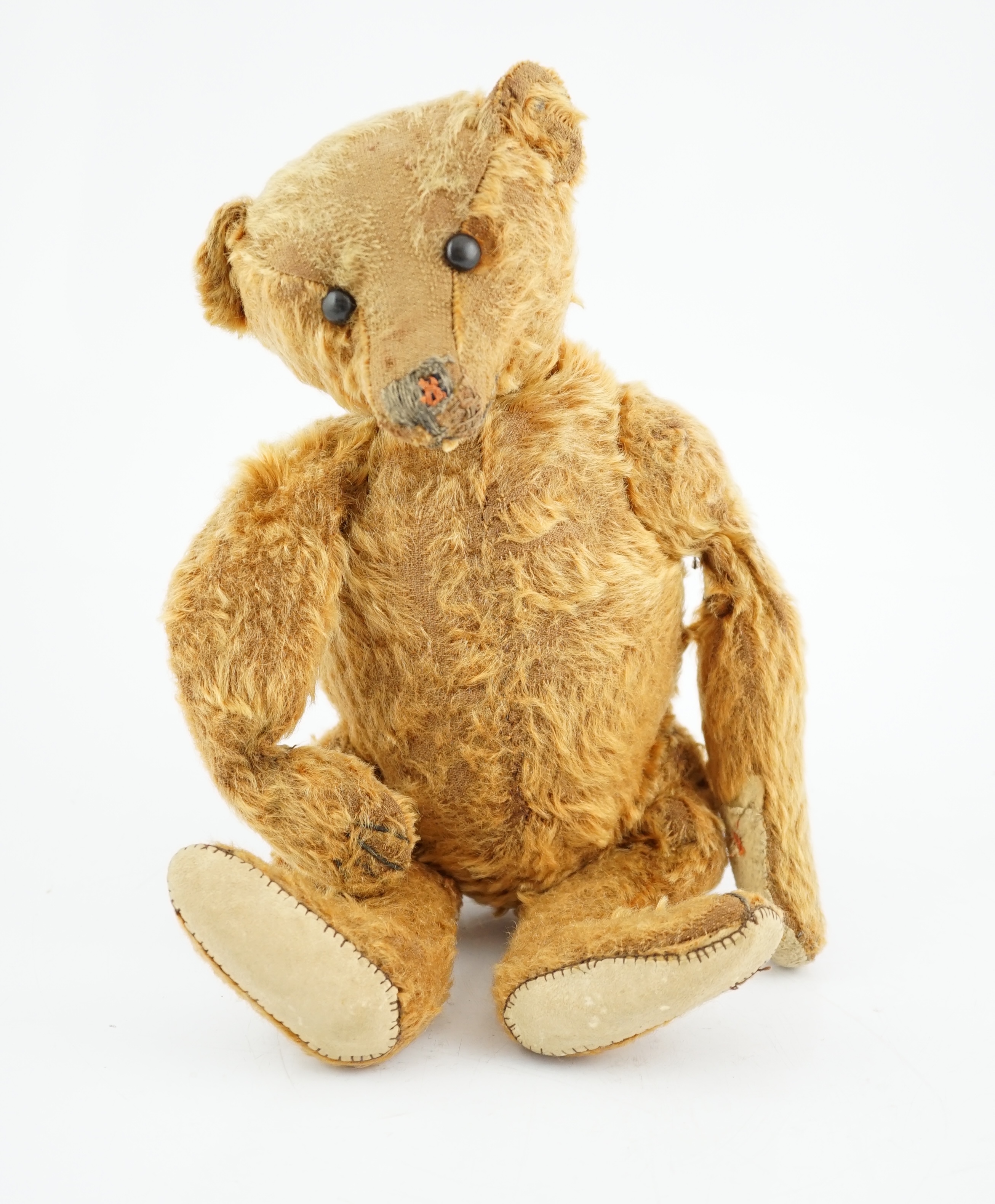 A cinnamon Steiff bear c.1908, with button paw pads, stuffing missing in arms, hair loss to head,